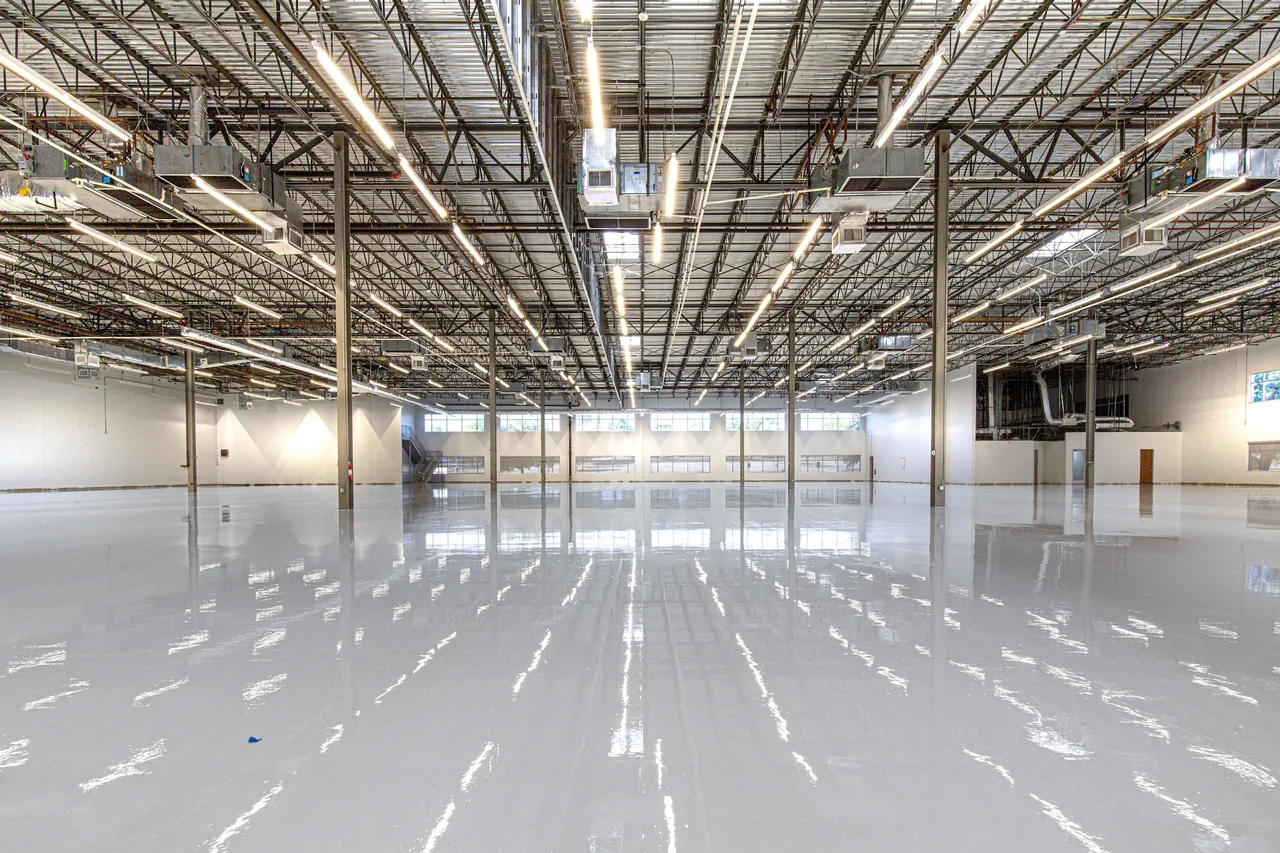 Glossy grey epoxy flooring across a large industrial facility